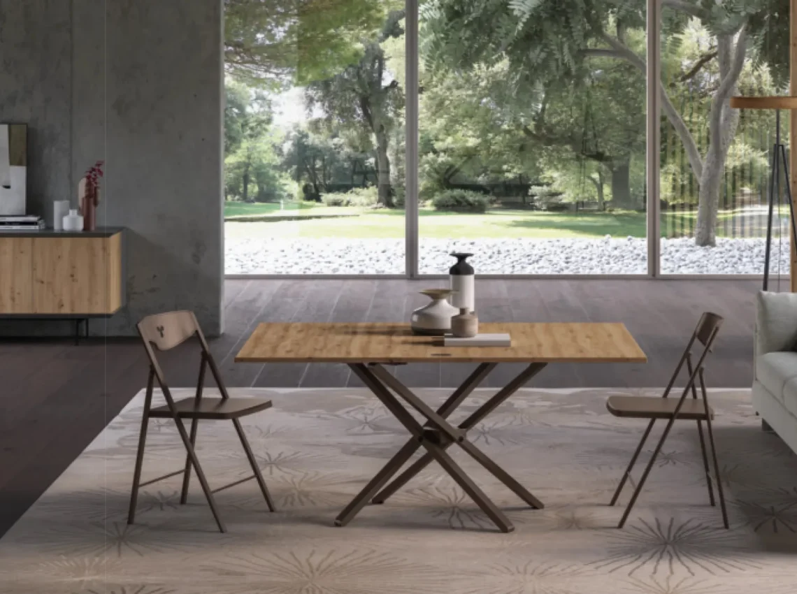 Tavolo Easyline con piano in vetro e struttura a cavalletto, sedie in tessuto chiaro.