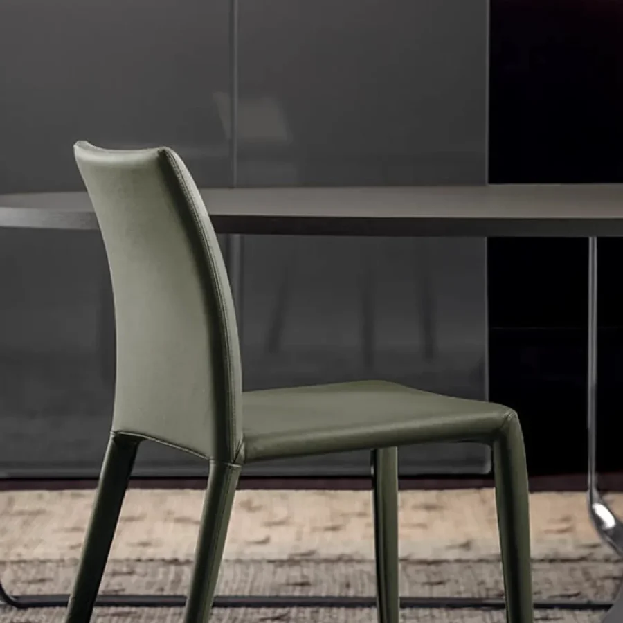 Sedia Pianca Emi in pelle verde oliva, design curvo e struttura essenziale.