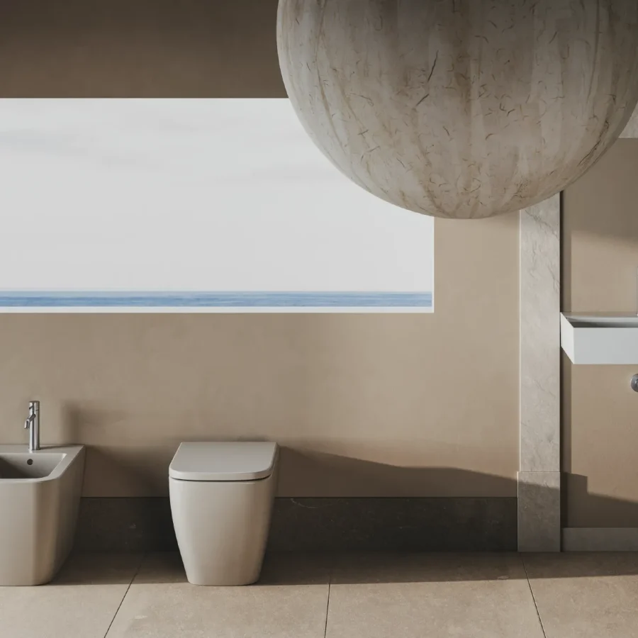 Sanitari a pavimento Hatria con lavabo sospeso su parete beige e vista mare, bagno moderno e luminoso.