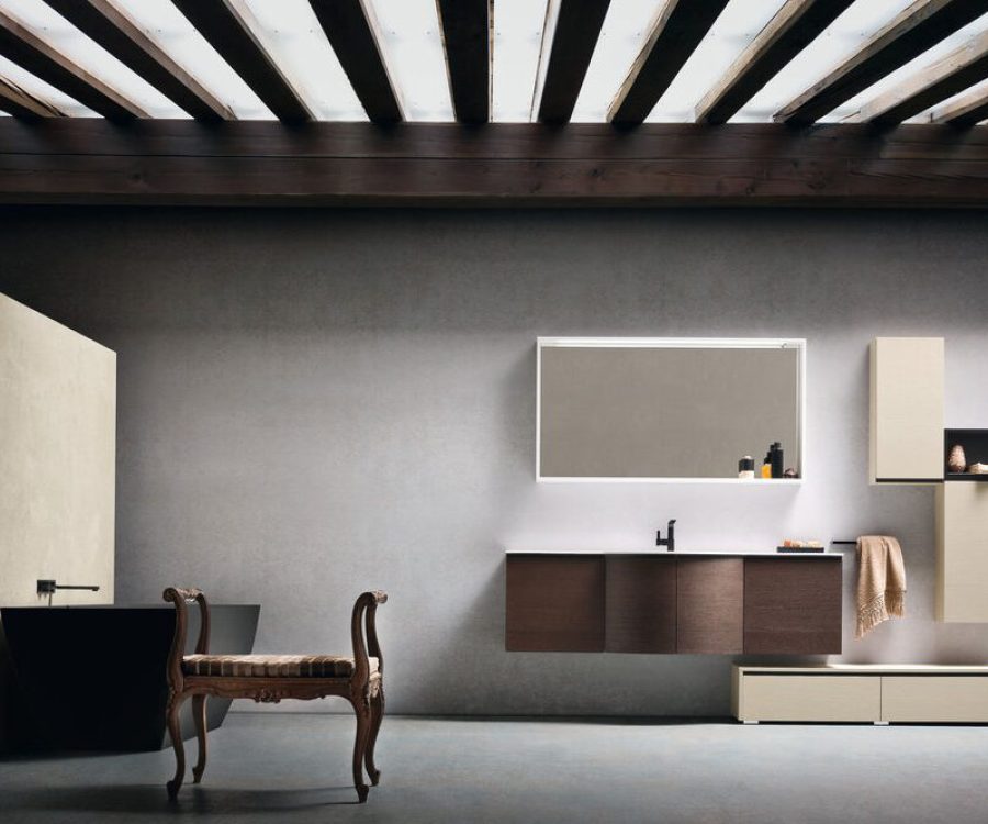 Arredo bagno sospeso con specchio retroilluminato in ambiente con travi a vista.