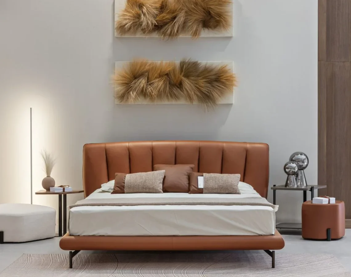 Letto con maxi testiera a pannelli verticali imbottiti, in tessuto beige.