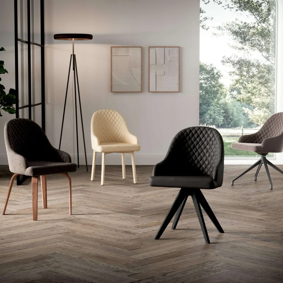 Sedie imbottite con lavorazione a rombi su schienale, su parquet chiaro.