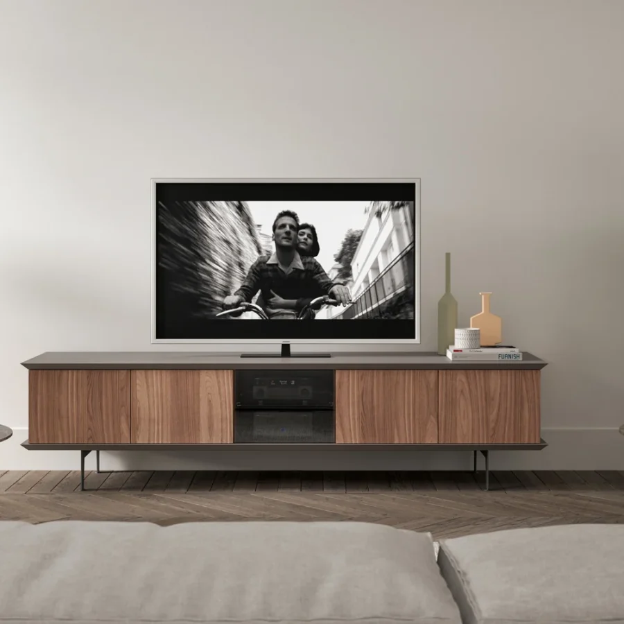 Mobile TV basso in legno chiaro con schermo acceso.