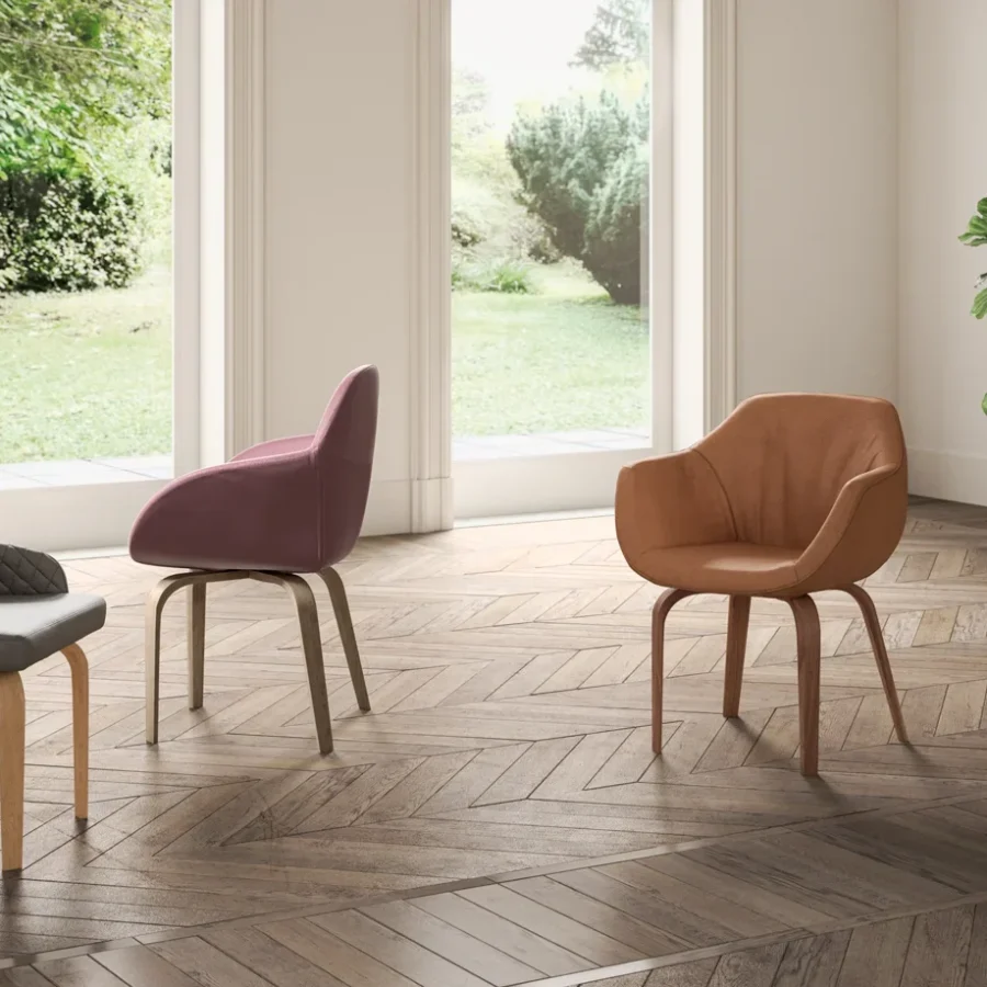 Sedie in pelle rosa e cuoio con struttura in legno chiaro.