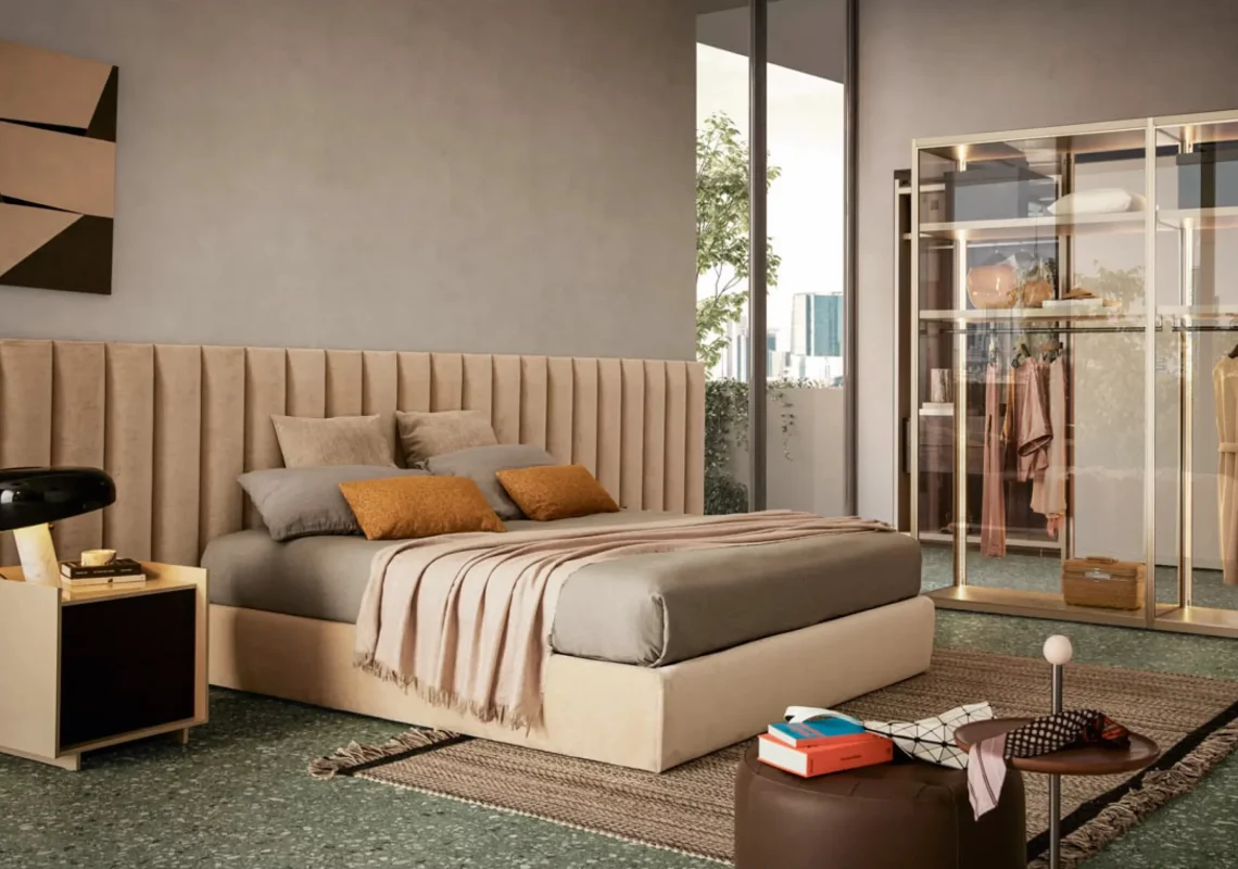 Letto moderno imbottito con testiera curva e rivestimento chiaro, ambientato in una stanza elegante dai toni neutri