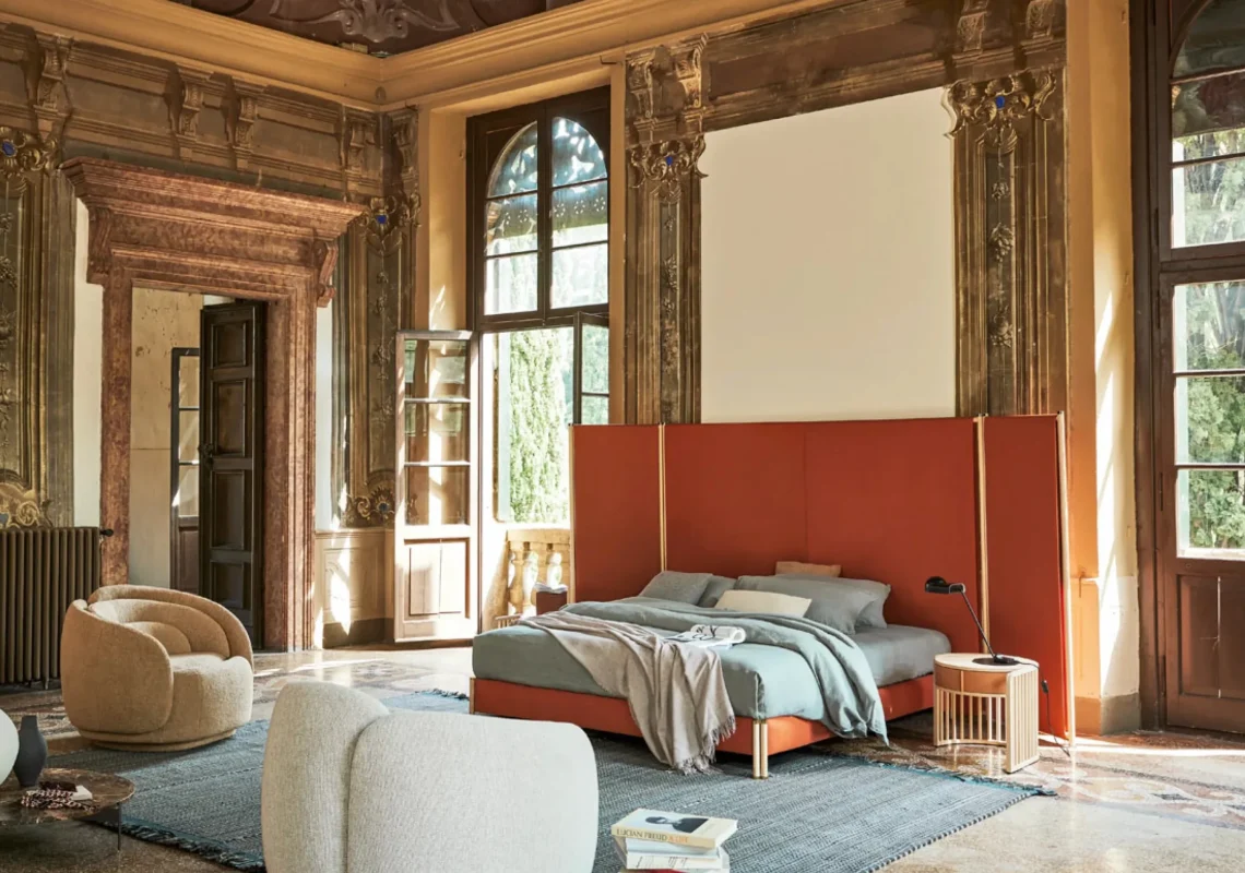 Letto tessile con struttura imbottita e pannello testiera a tutta altezza in tessuto arancio