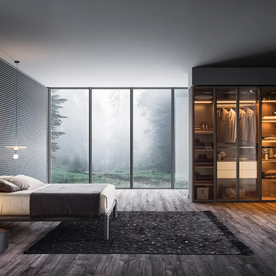 Cabina armadio ad angolo con ante in vetro e illuminazione integrata.