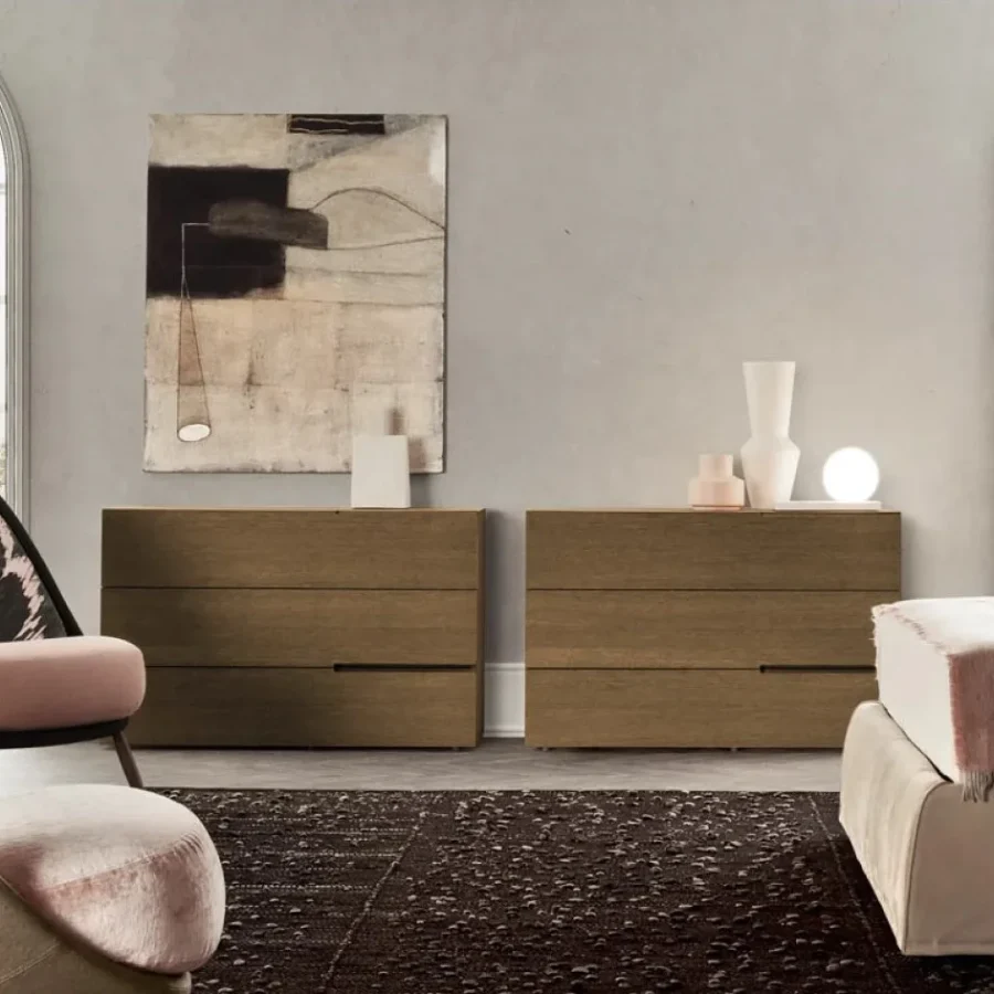 Camera da letto elegante con due cassettiere affiancate in legno naturale e opere d'arte alle pareti.
