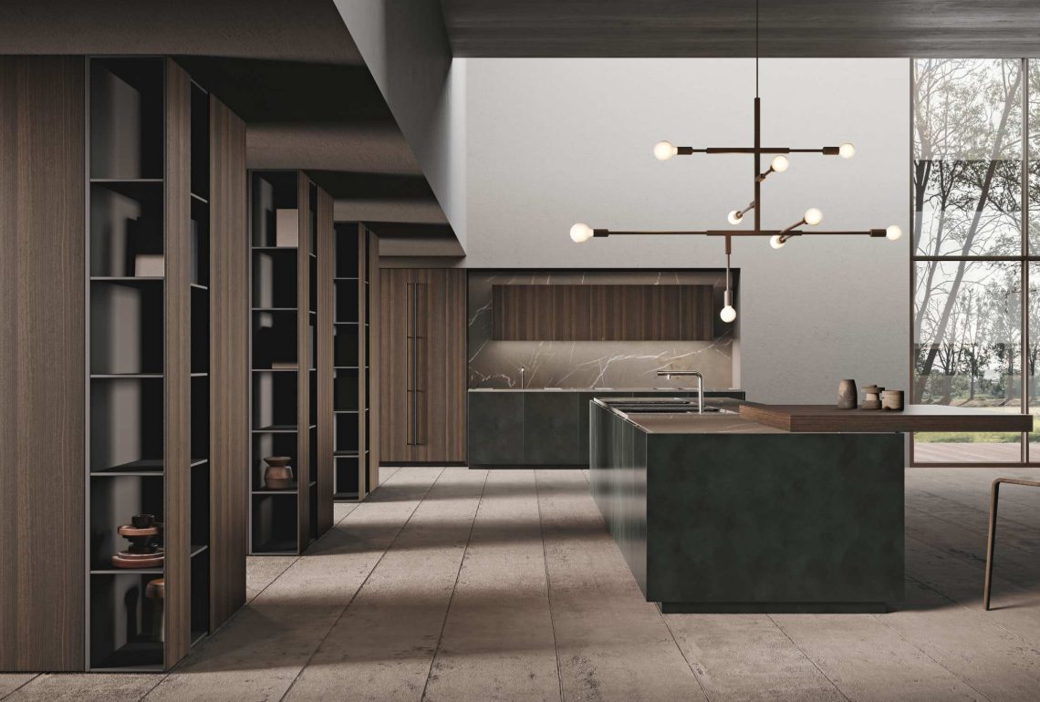 Dettaglio laterale della cucina verde scuro con boiserie a colonne e piano snack in legno, illuminata da una grande finestra.