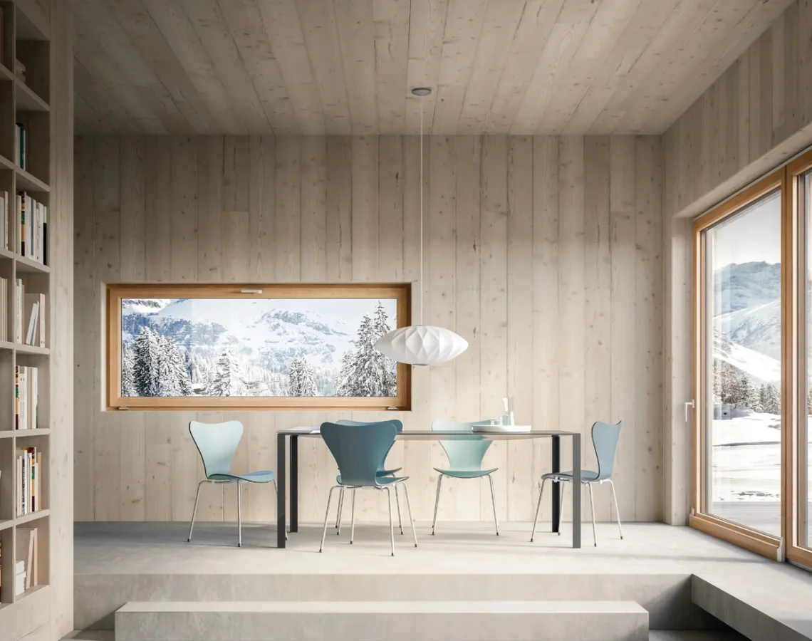 Sala da pranzo con grandi vetrate affacciate su paesaggio montano innevato