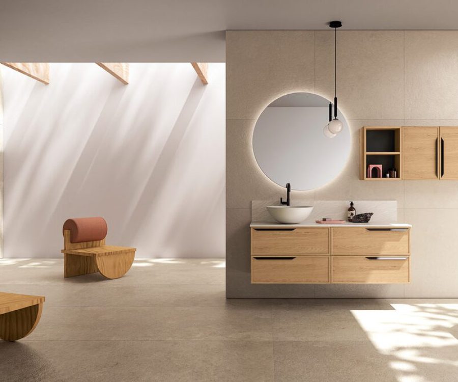 Mobile bagno sospeso con lavabo d'appoggio e specchio rotondo retroilluminato.