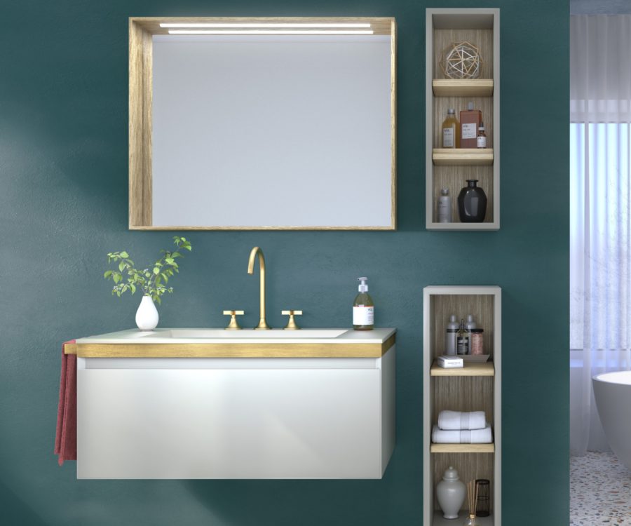 Arredo bagno sospeso bianco con top in legno chiaro, rubinetteria oro e mensole incassate su parete verde petrolio.